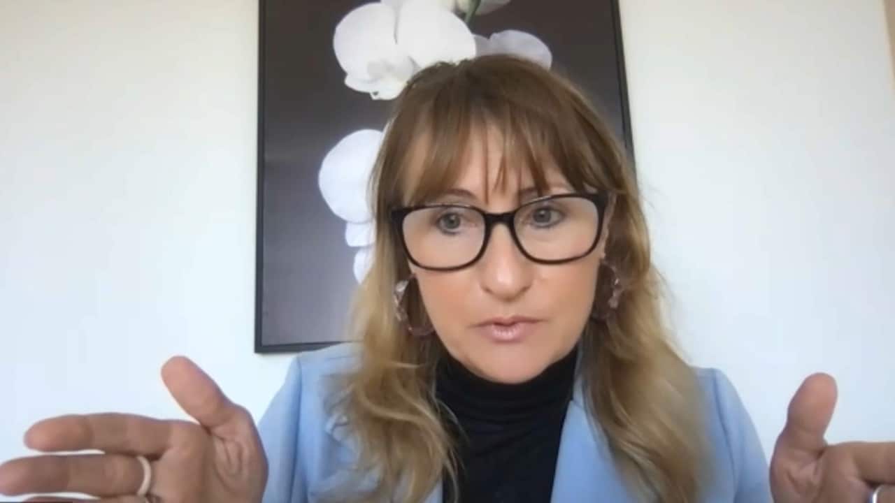 Woman in glasses in light blue blazer.