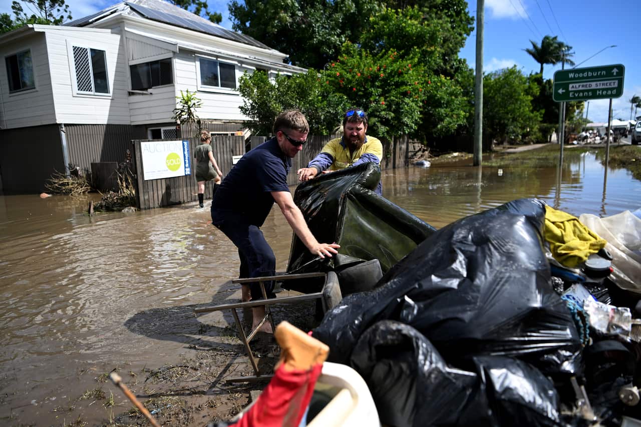 Woodburn residents are seen removing damaged iterms from a flood-affected house.