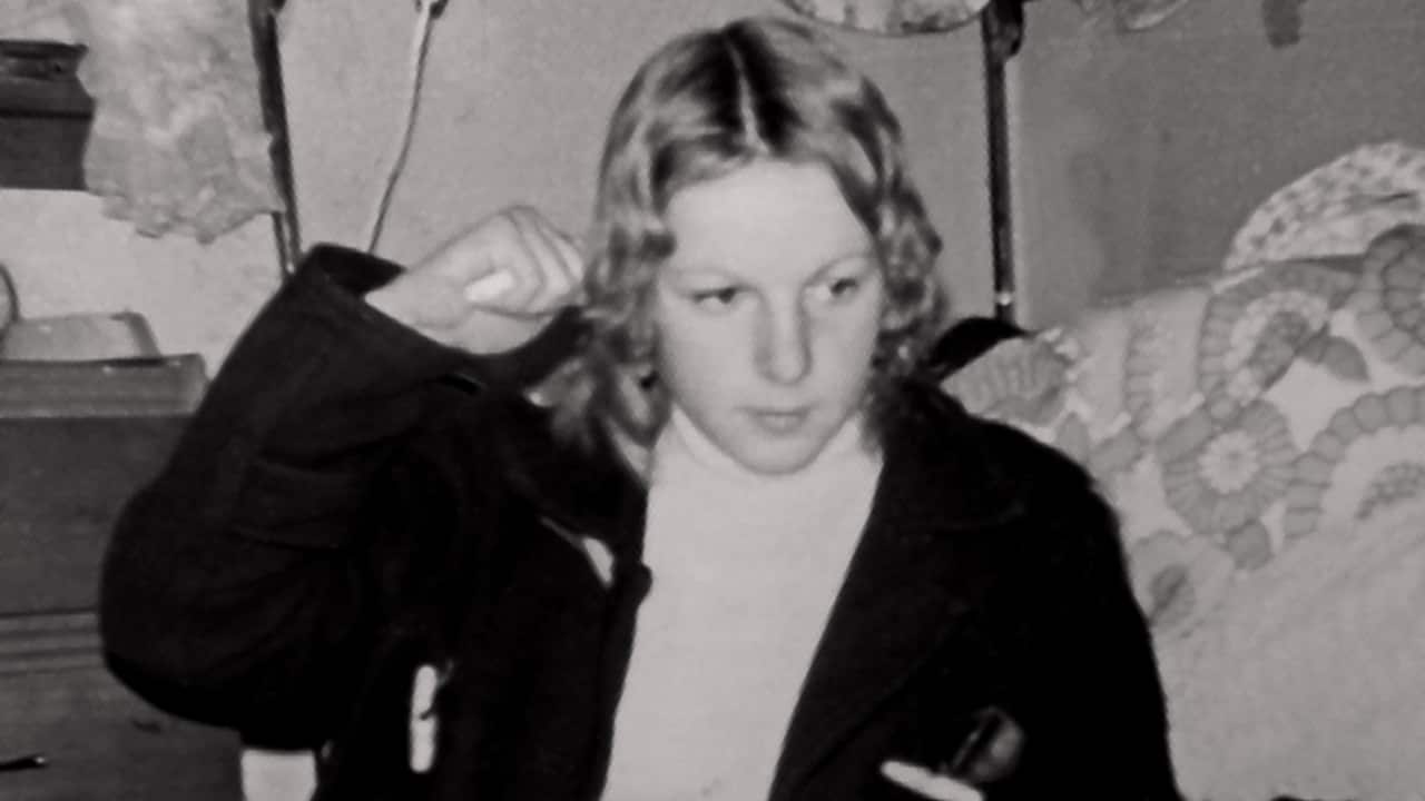 a black and white photo of a young teenage girl with a bob in a bedroom