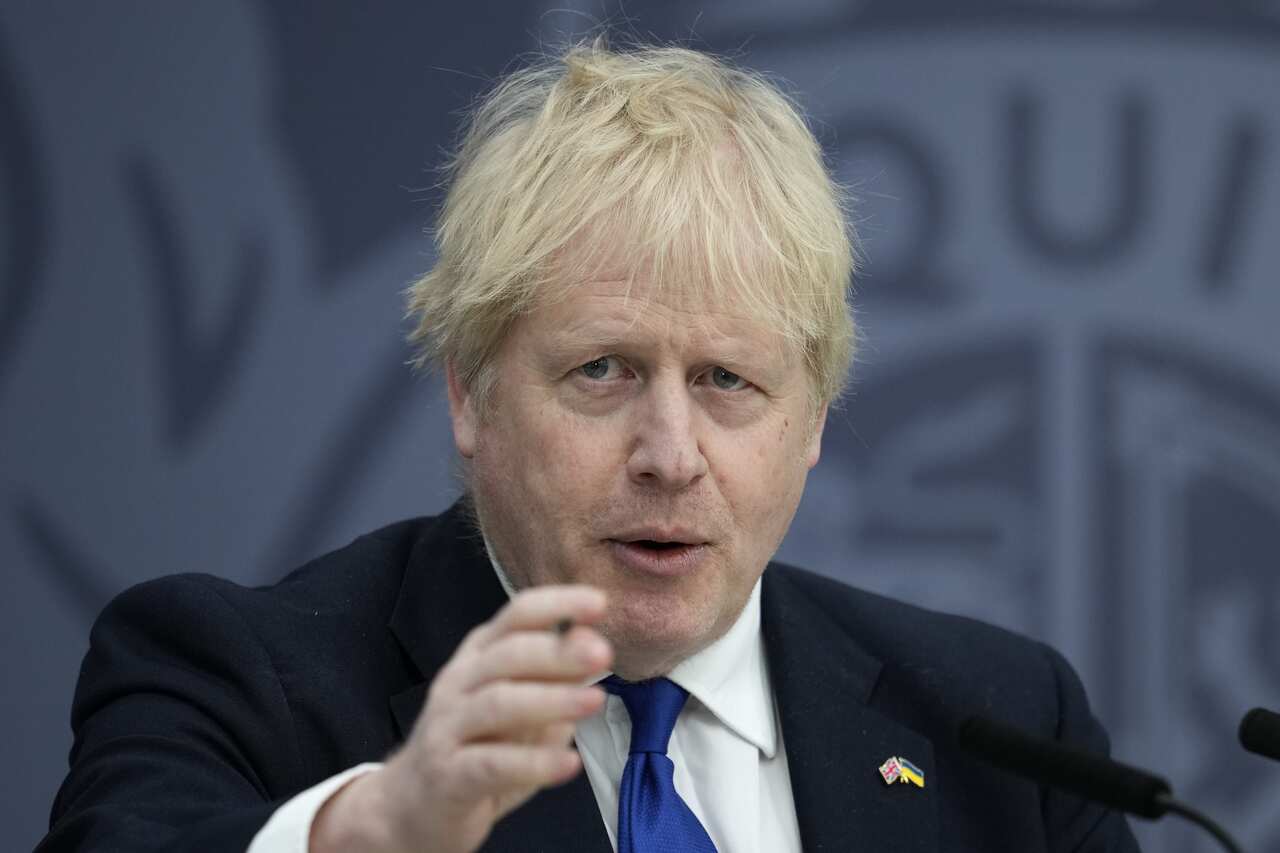 UK Prime Minister Boris Johnson points his hand to the camera during a press conference.