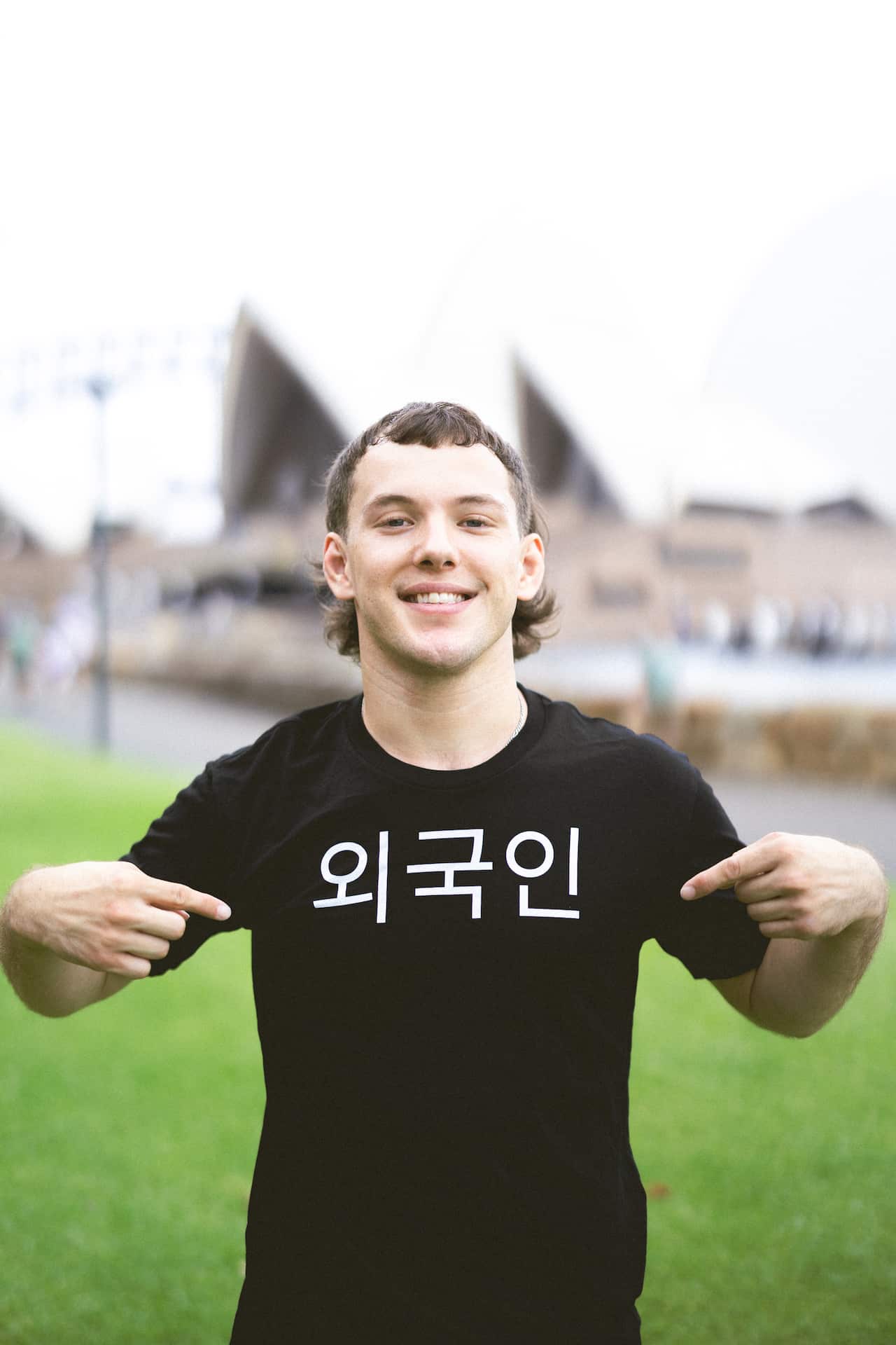 A man wearing a black t-shirt points at his chest