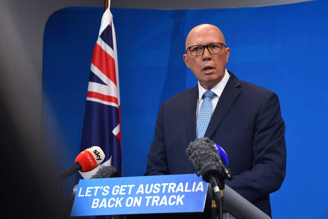 Peter Dutton stands at a lectern that shows a sign saying 'Let's get Australia back on track'.