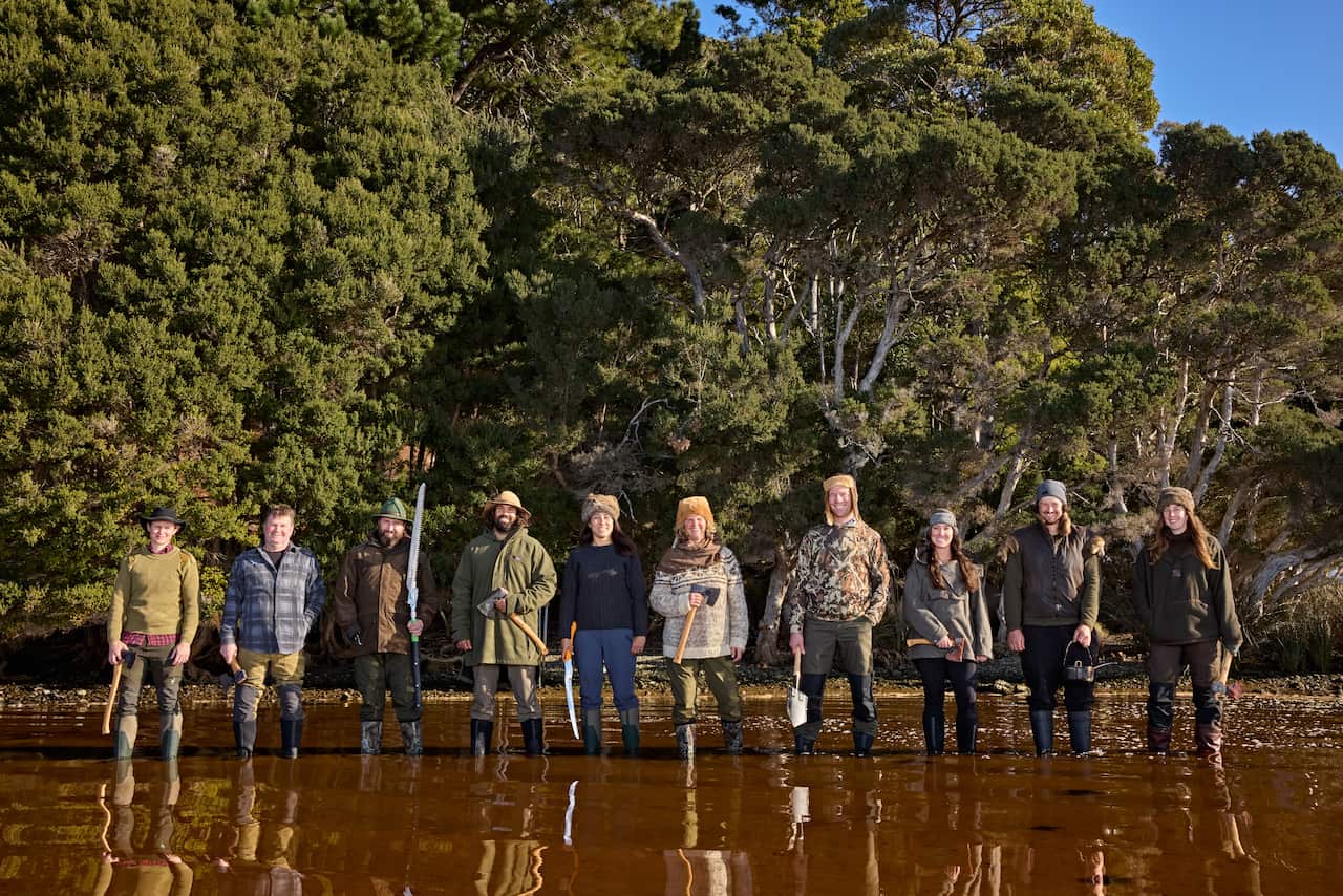 A group of people standing in shallow waters.