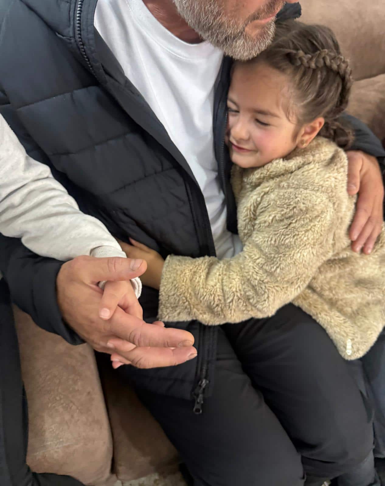 A little girl holds a man