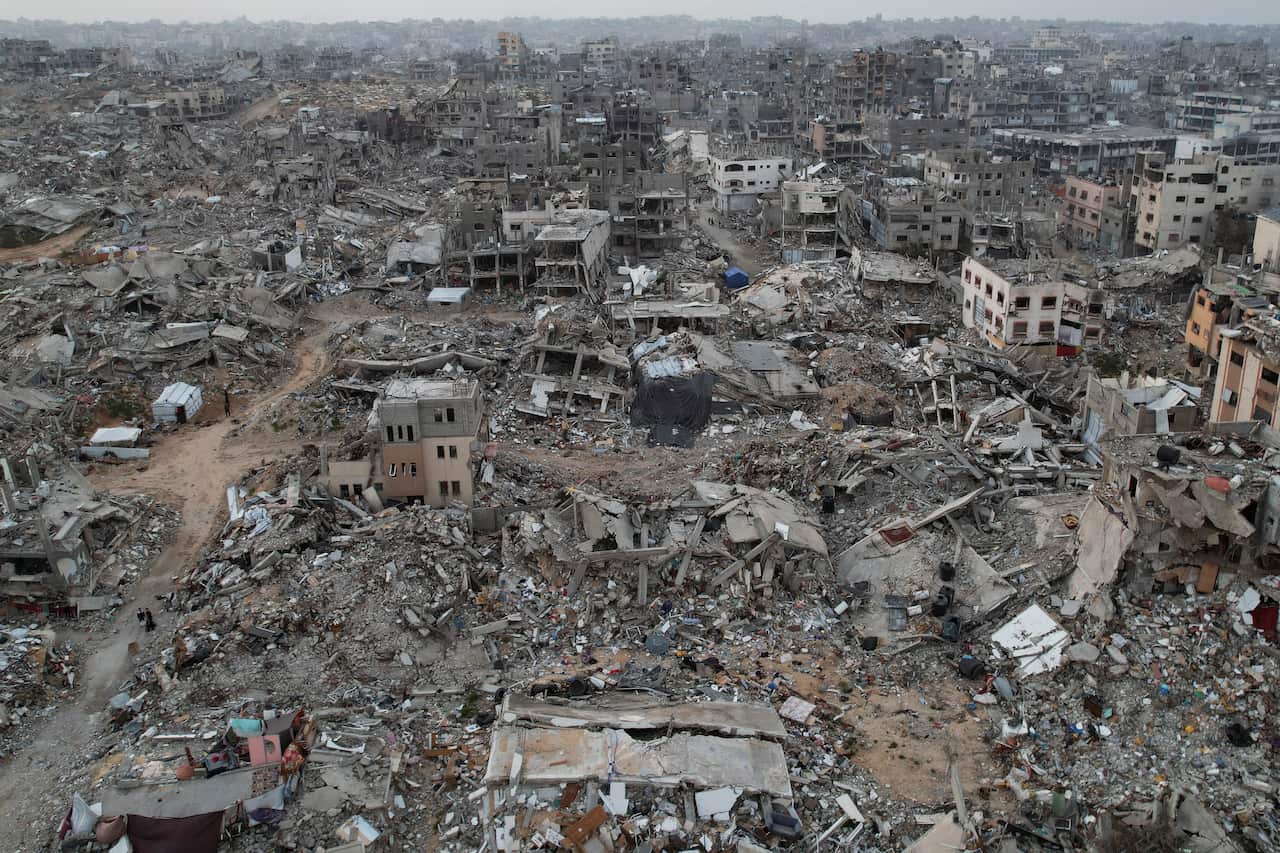 Aerial drone photograph shows widespread destruction, showing collapsed buildings and rubble across the densely built-up area.