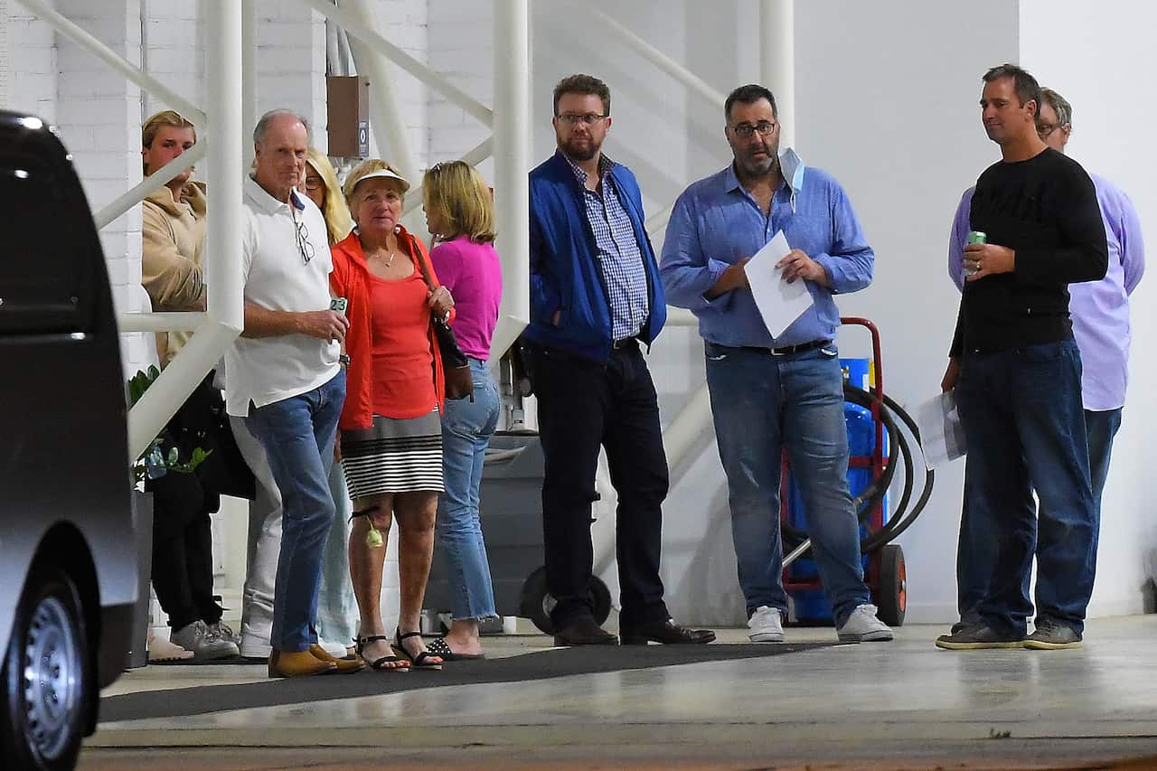 Parents of Shane Warne Keith,  Bridgette, and son Jackson Warne, look on as a white van departs from a hangar at Essendon Airport in Melbourne