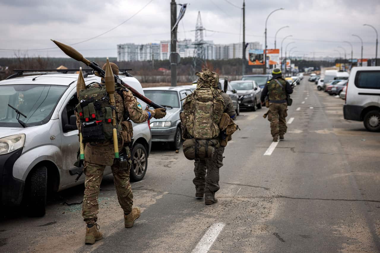 Ukrainian servicemen are seen carrying rocket-propelled grenades and sniper rifles.