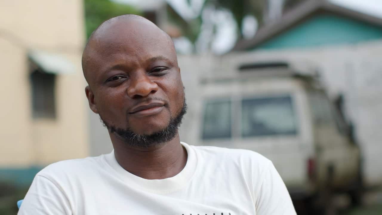 A man with a short beard wearing a white T-shirt