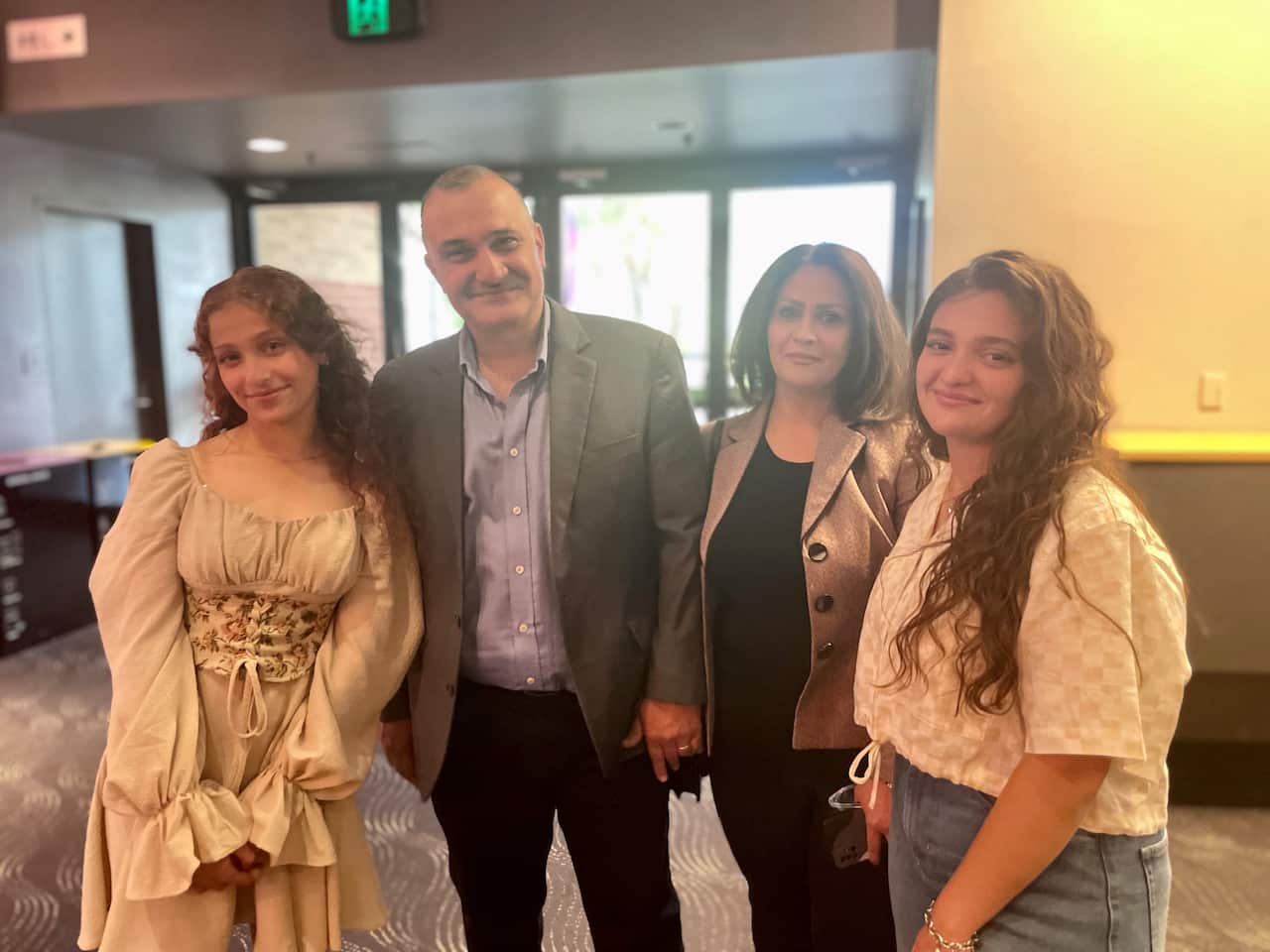 Four people stand together.