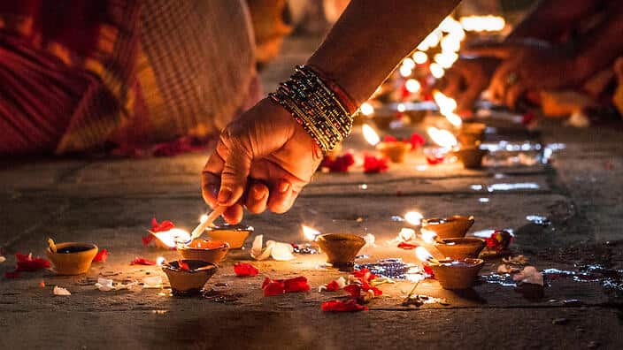 Close-Up Of Hand Holding Illuminated Candles