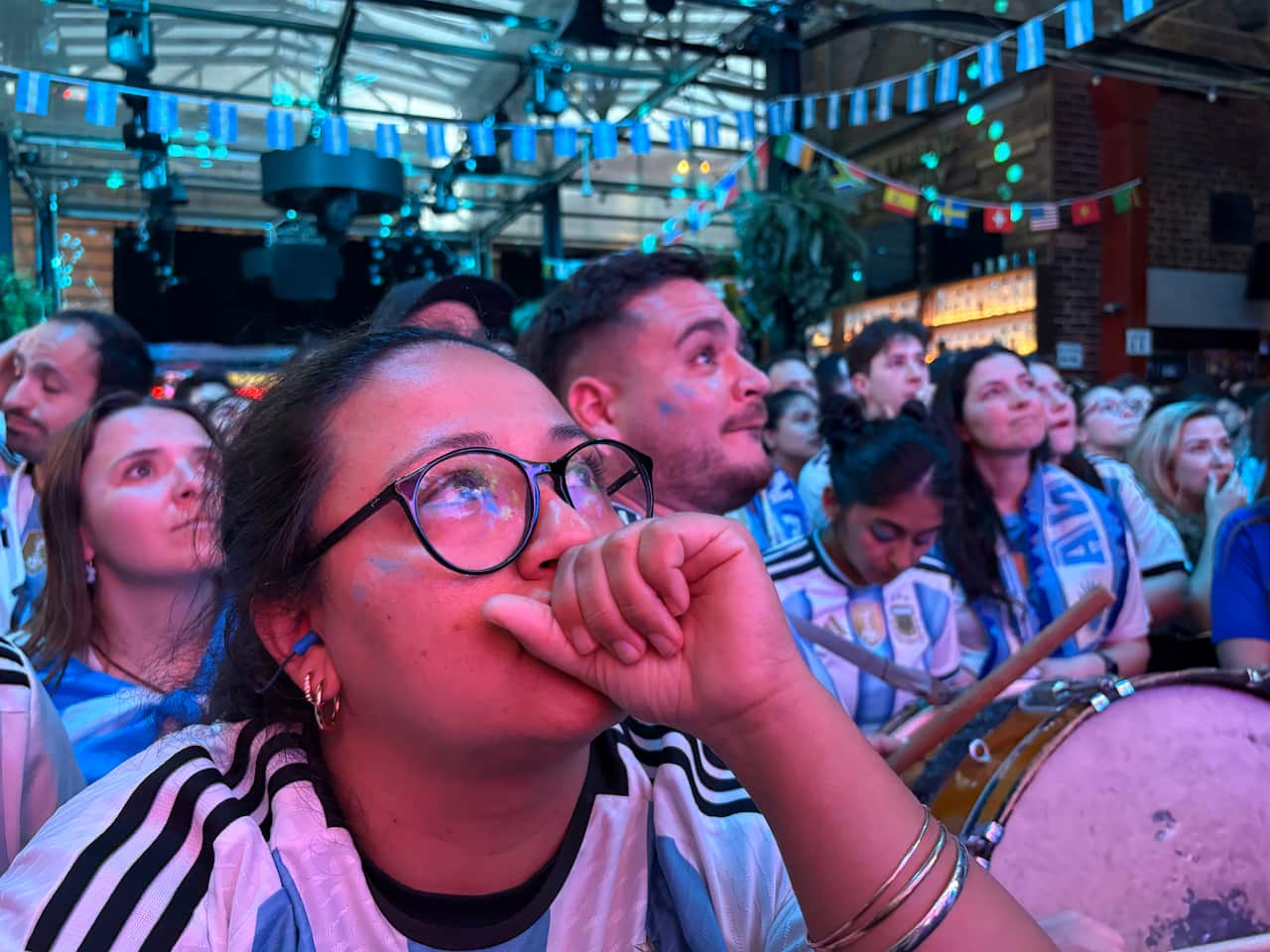 Football fans in Argentina shirts watch nervously at a public screening of the World Cup final between Spain and Argentina.