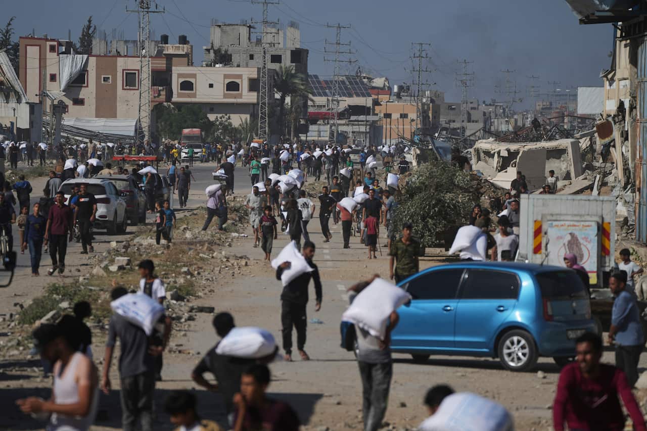 Palestinians carrying bags of flour