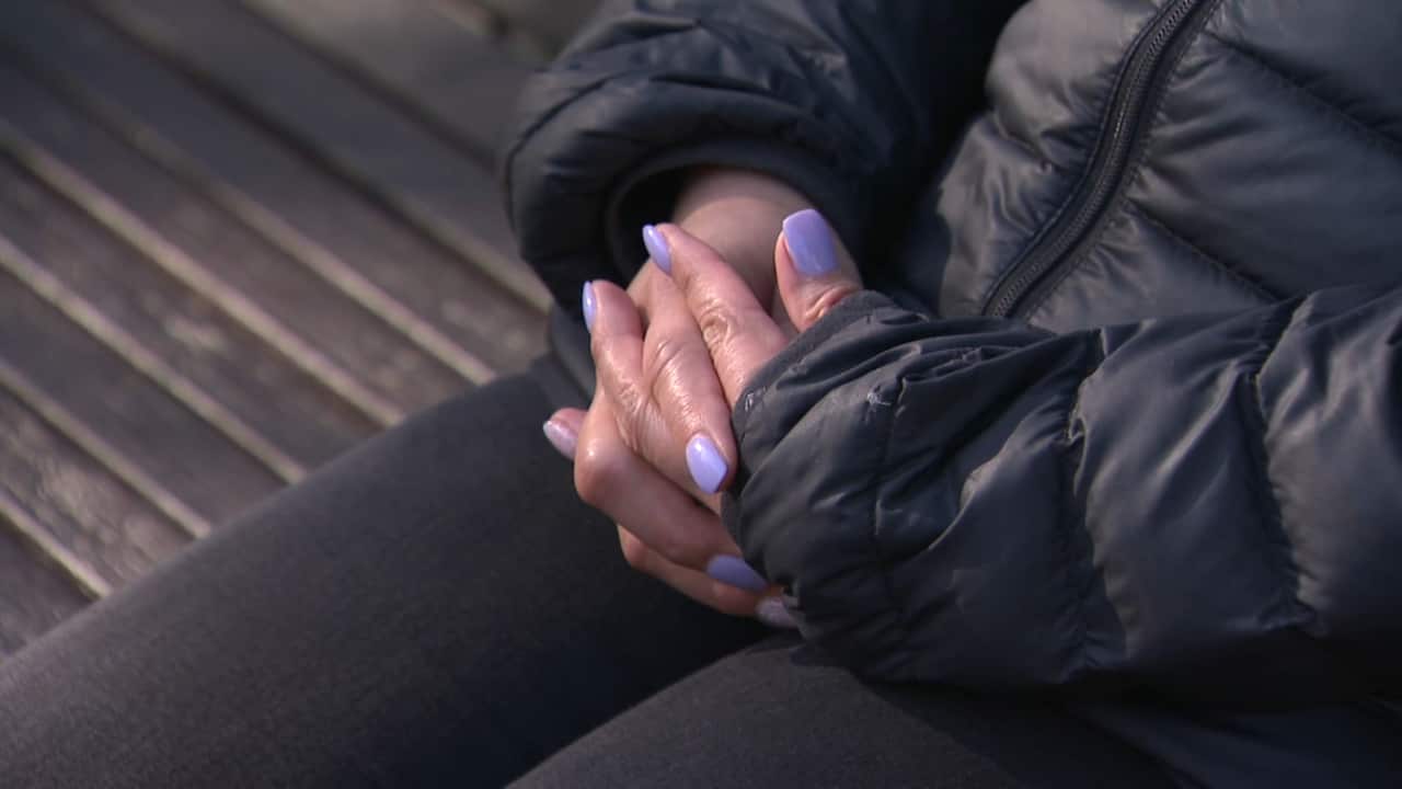 Close up of a woman's hands with purple nailpolish on