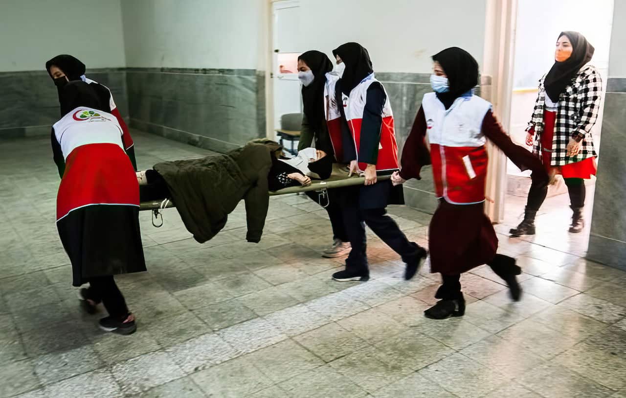 Women carry a girl on a stretcher 
