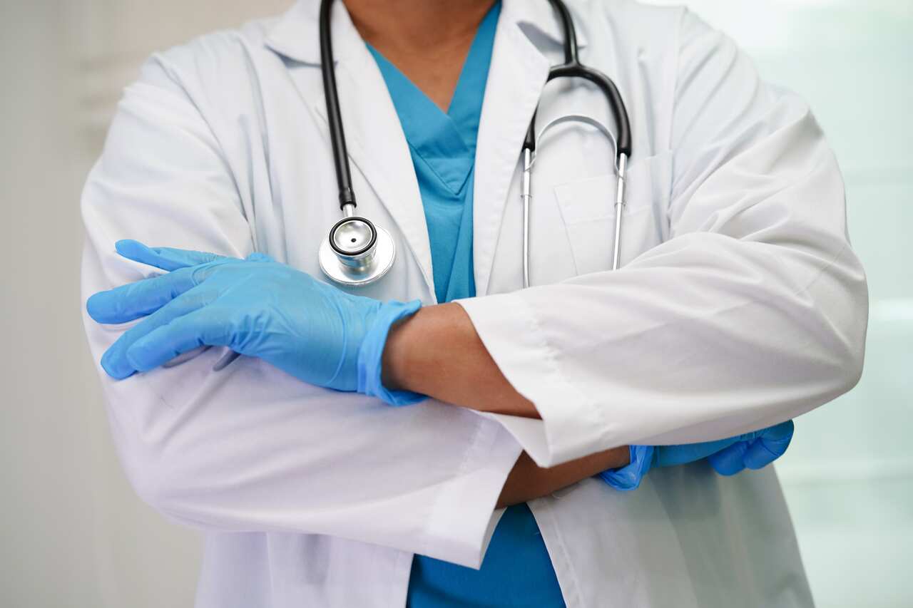 Asian woman doctor holding red heart for health in hospital.