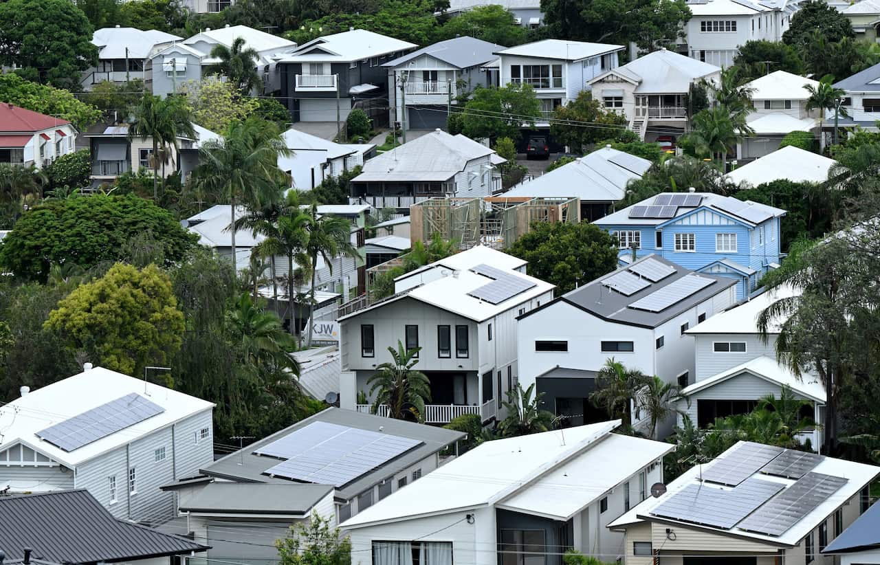 Several rows of houses among green trees.