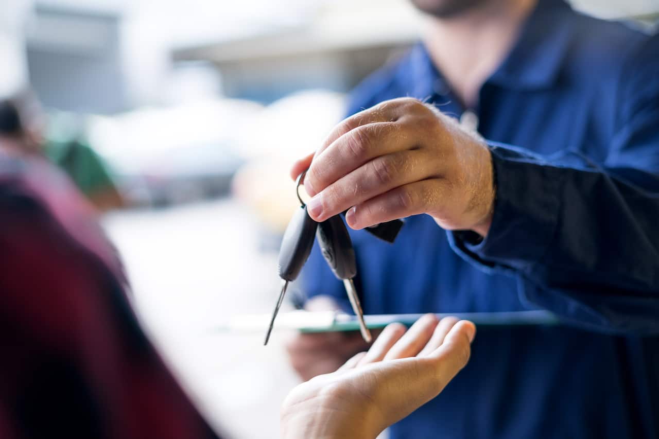 Car repairman giving car keys to customer