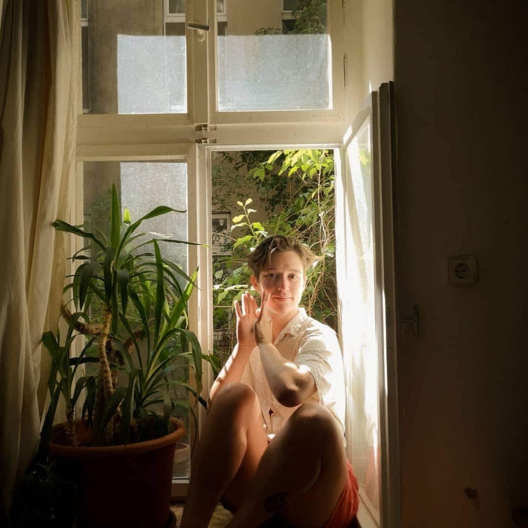 A woman sitting in a windowsill.