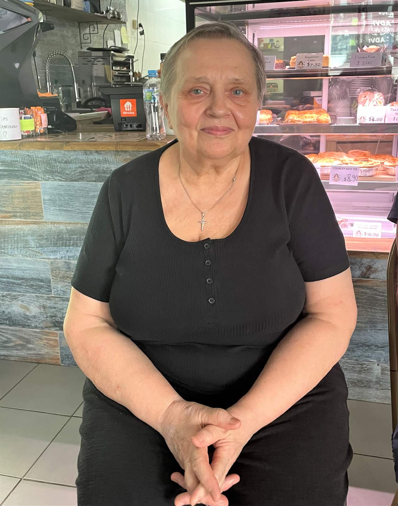 A woman sitting in front of a cafe counter