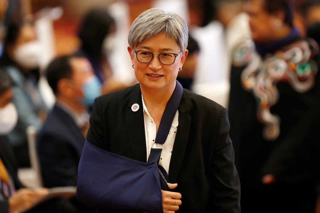 Penny Wong in a sling, walking