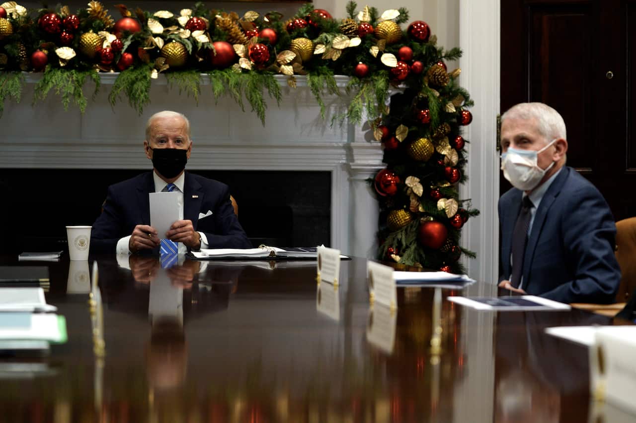Joe Biden and Anthony Fauci sitting at a table wearing face masks.