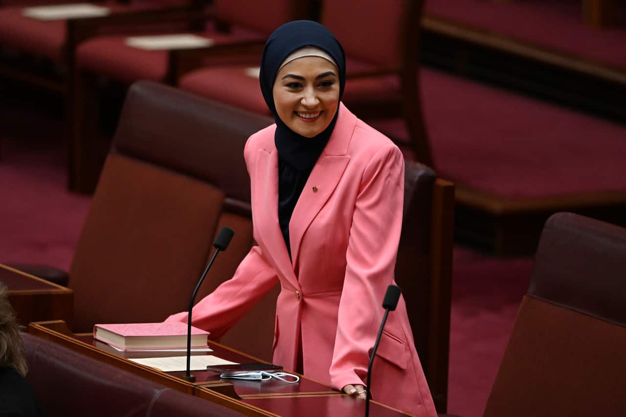 Senator Payman, wearing a black hijab and a pink coat, in the Senate chamber at Parliament House in Canberra.