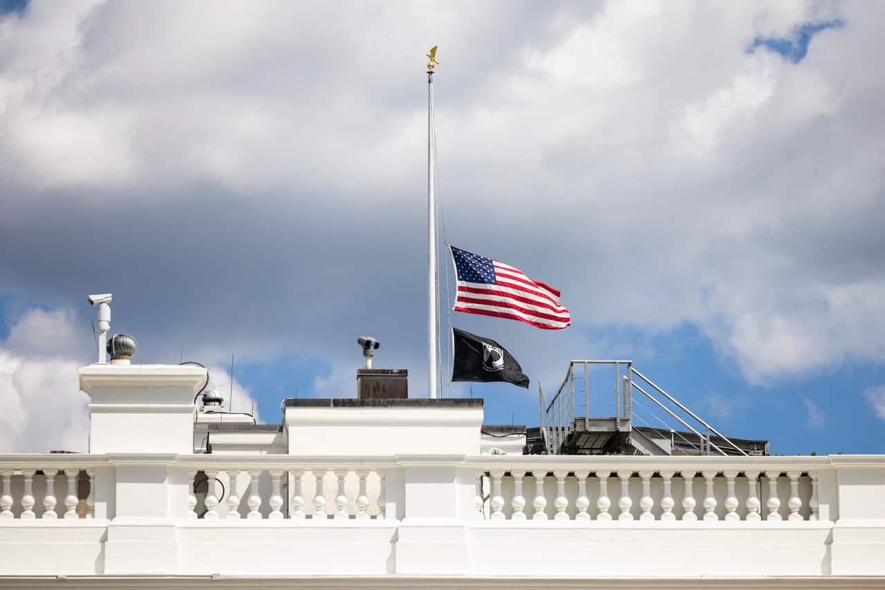Flags lowered to half-mast on the White House roof.