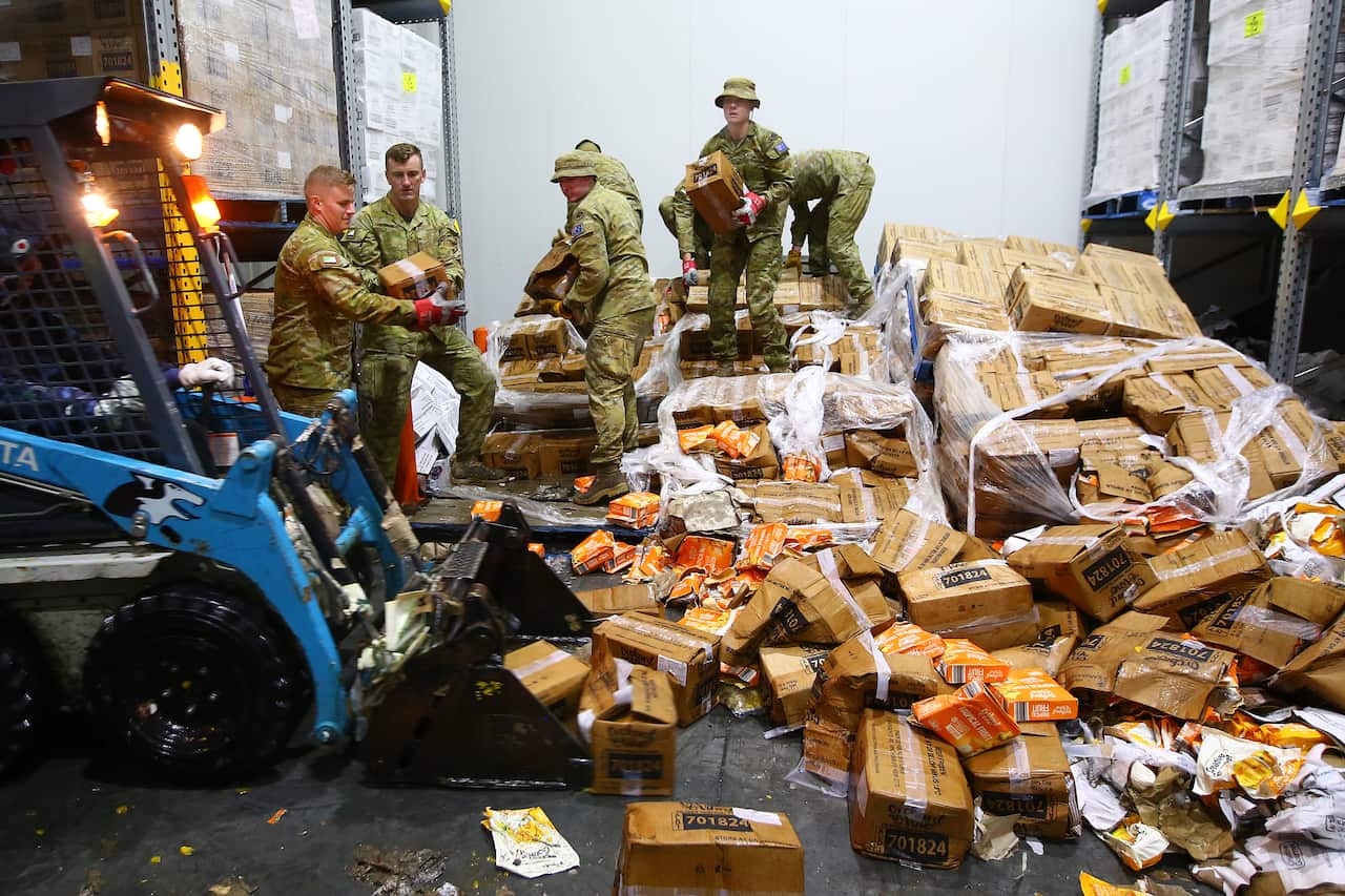 Australian Defence Force personnel are seen cleaning up a storage facility.