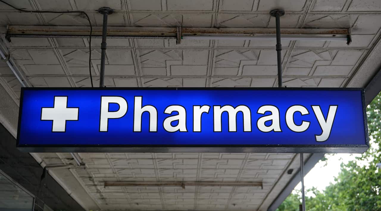 A blue sign with a white cross and the word 'Pharmacy' on it.