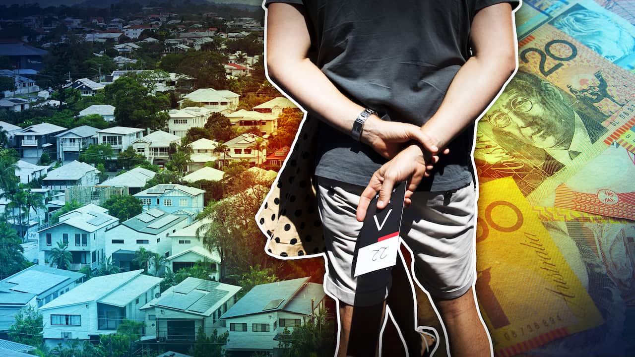 The back of a man holding an auction card, with houses and Australian bills in the background.