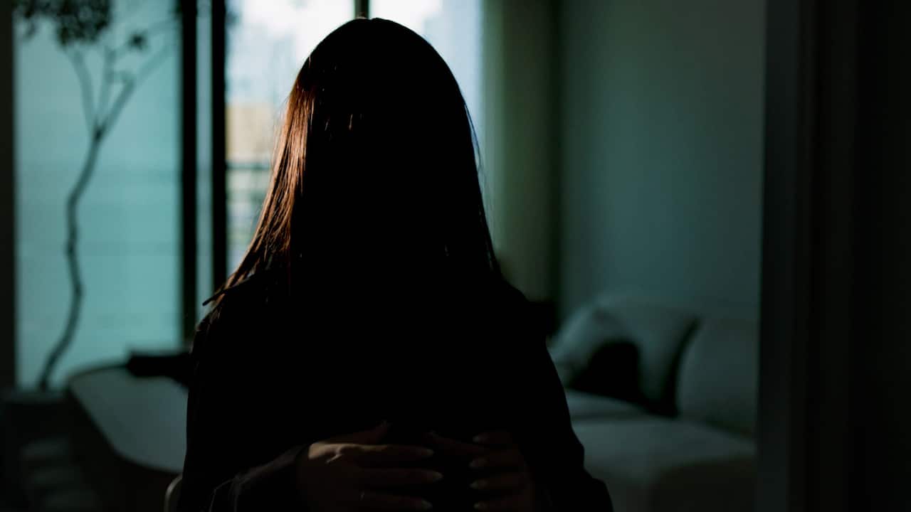A dark silhouette of a woman with long hair 