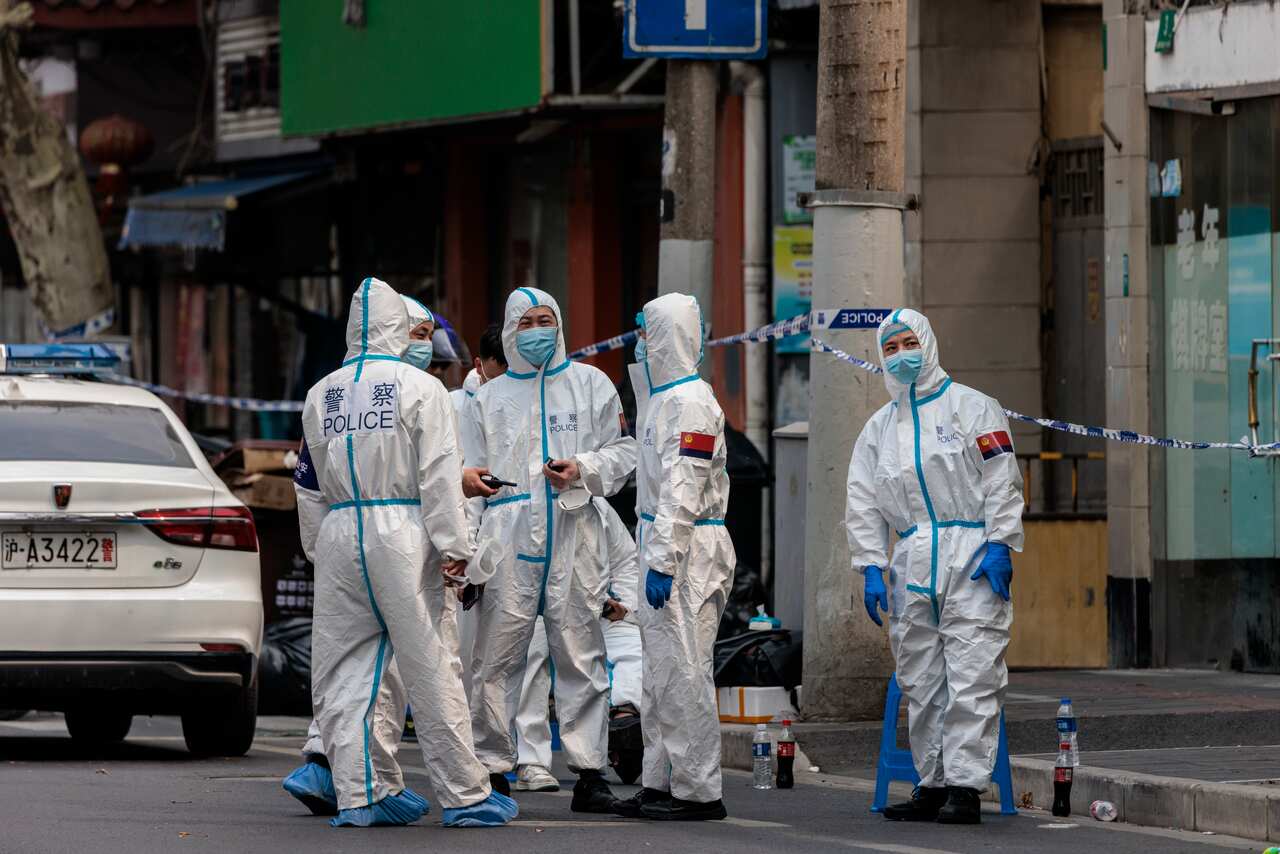 Health workers and police are seen wearing protective equipment.