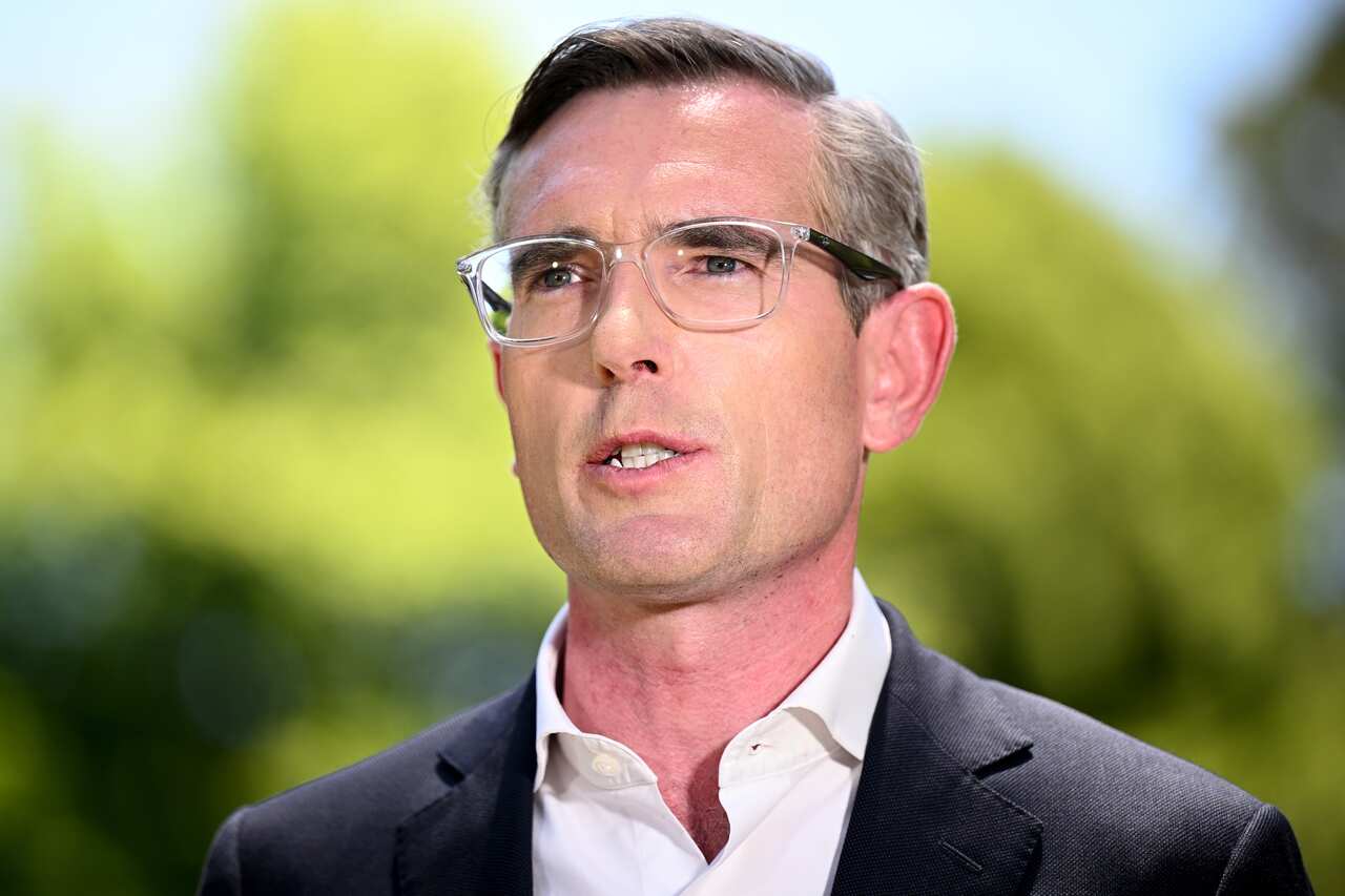 A man wearing a suit addresses the media. 