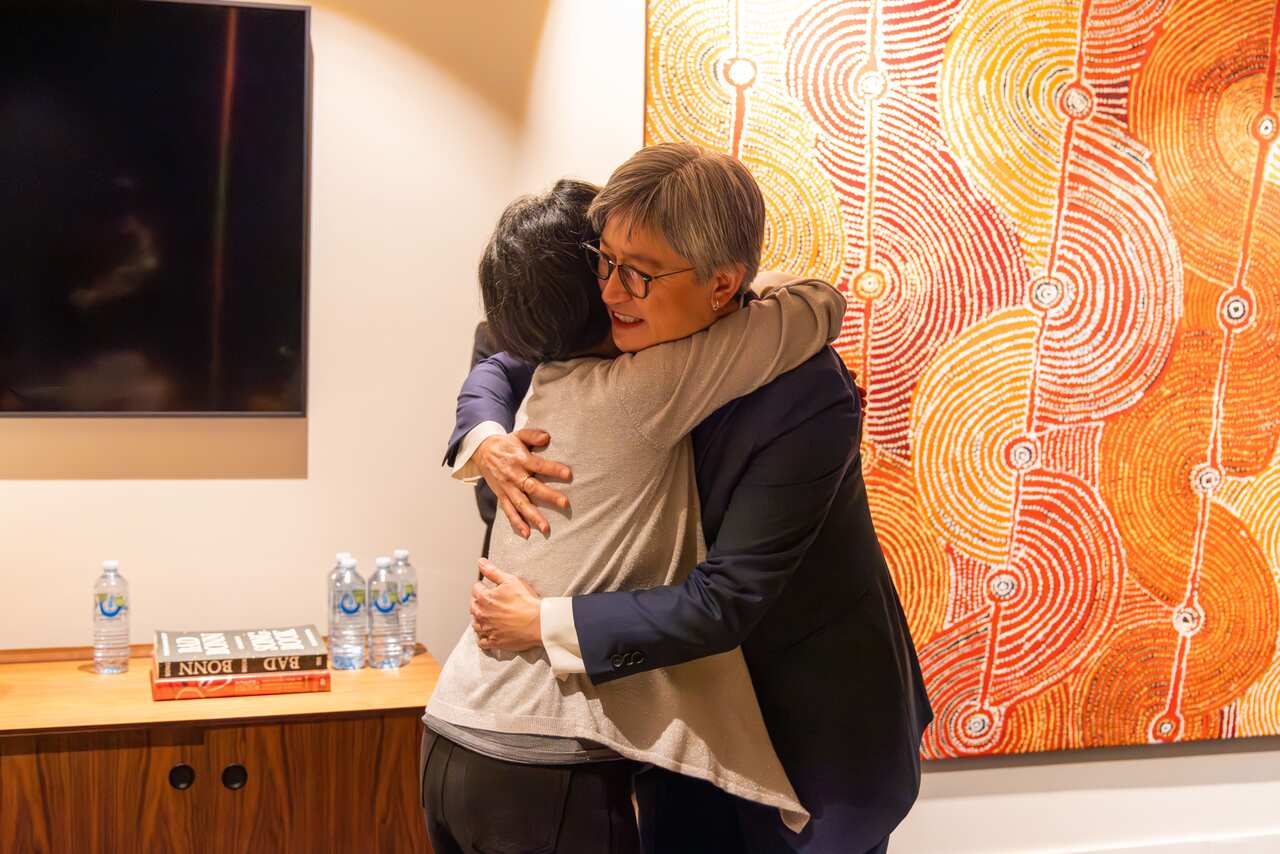 Penny Wong and Cheng Lei embracing.