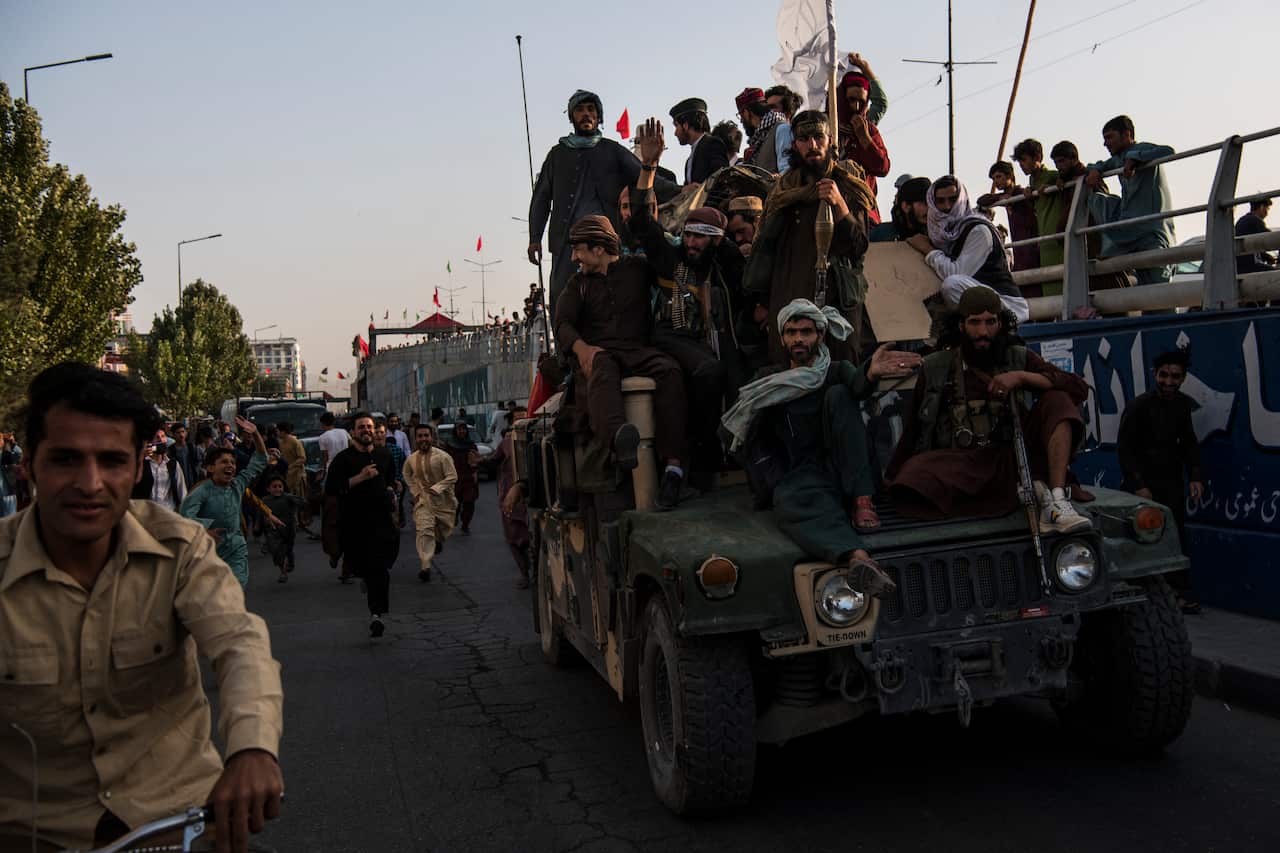Taliban fighters atop an American-made armoured Humvee.