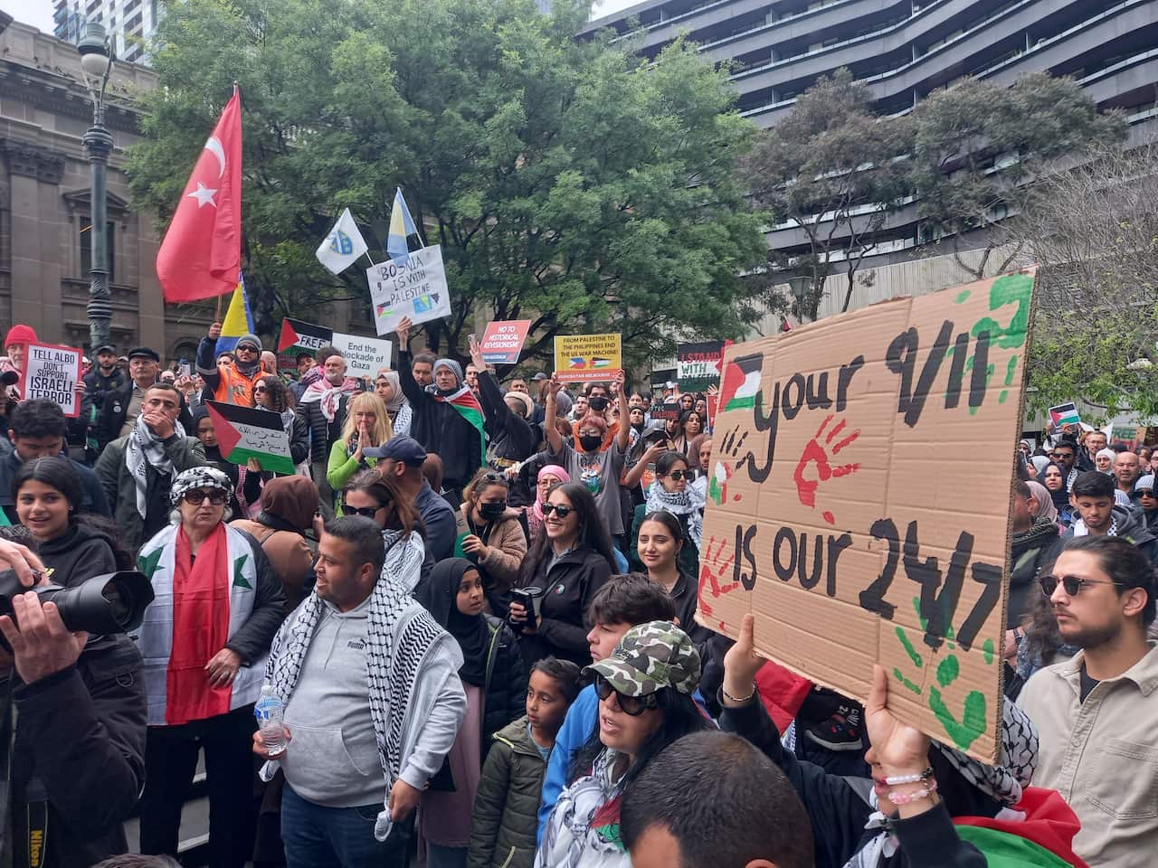 A group of protesters at a rally holding up signs.
