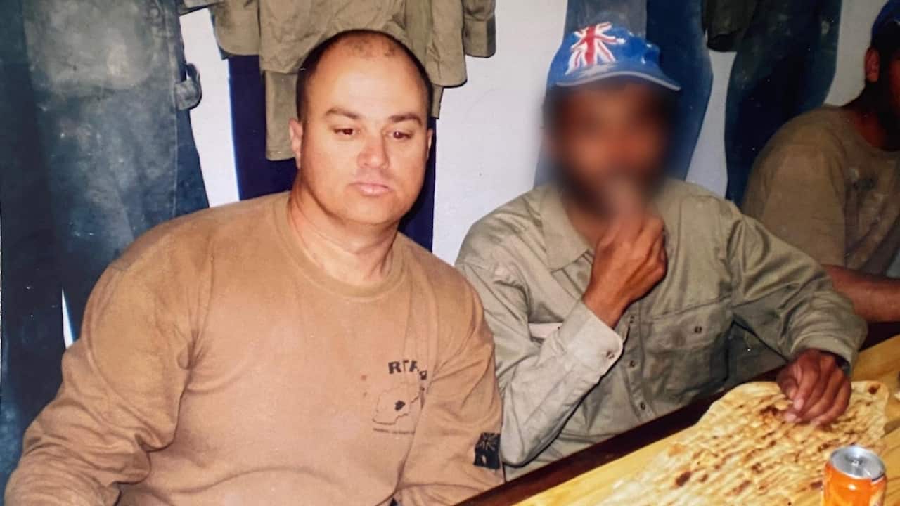 Warren having a meal with an Afghan instructor. The instructors face has been blurred. 