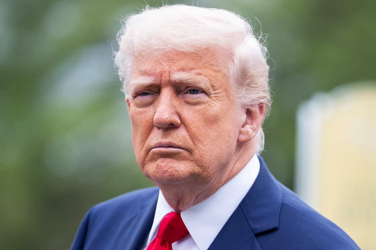 A close up of Donald Trump wearing a blue suit and red tie