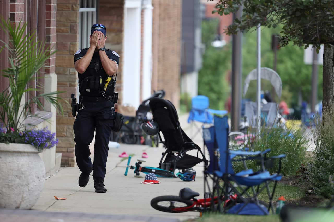 A Lake County police officer covers his face in shock as he reacts to the shooting.