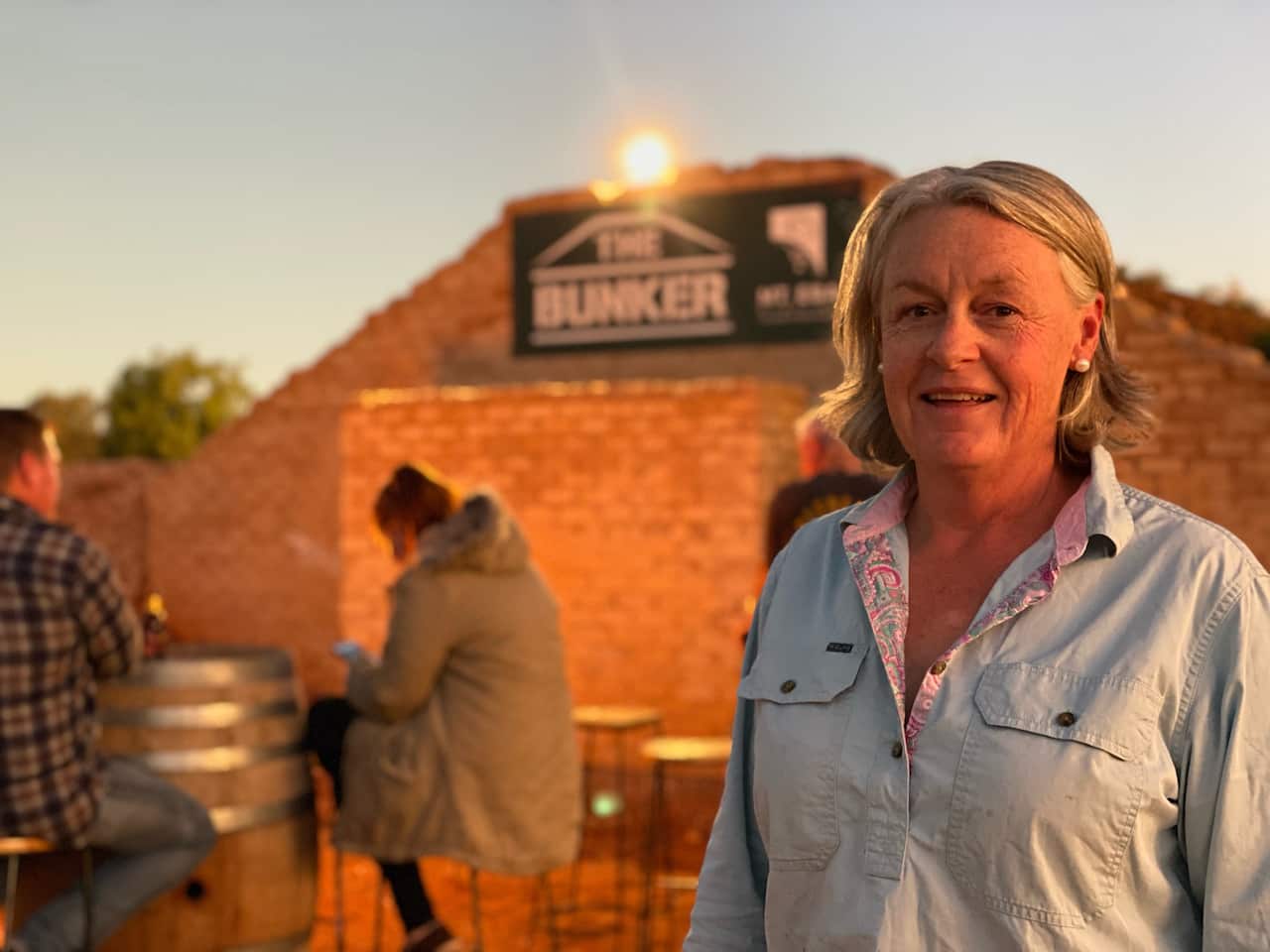 Woman standing in front of disused bomb shelter.