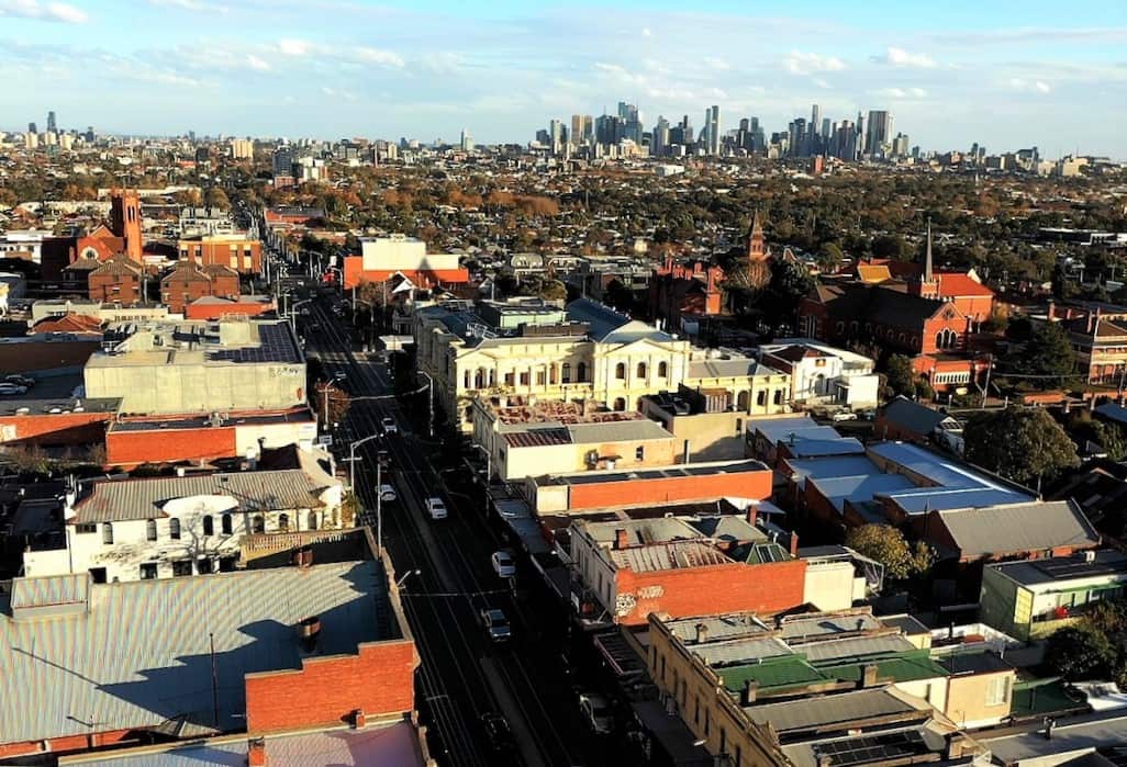 An aerial view of a shopping street with historic buildings and city sky scrapers in the background.