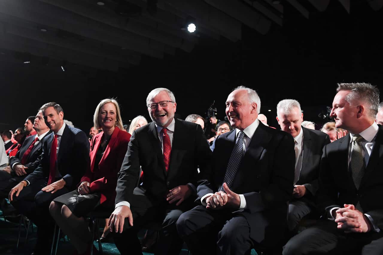 Past and present Labor politicians sit on chairs in a conference room.