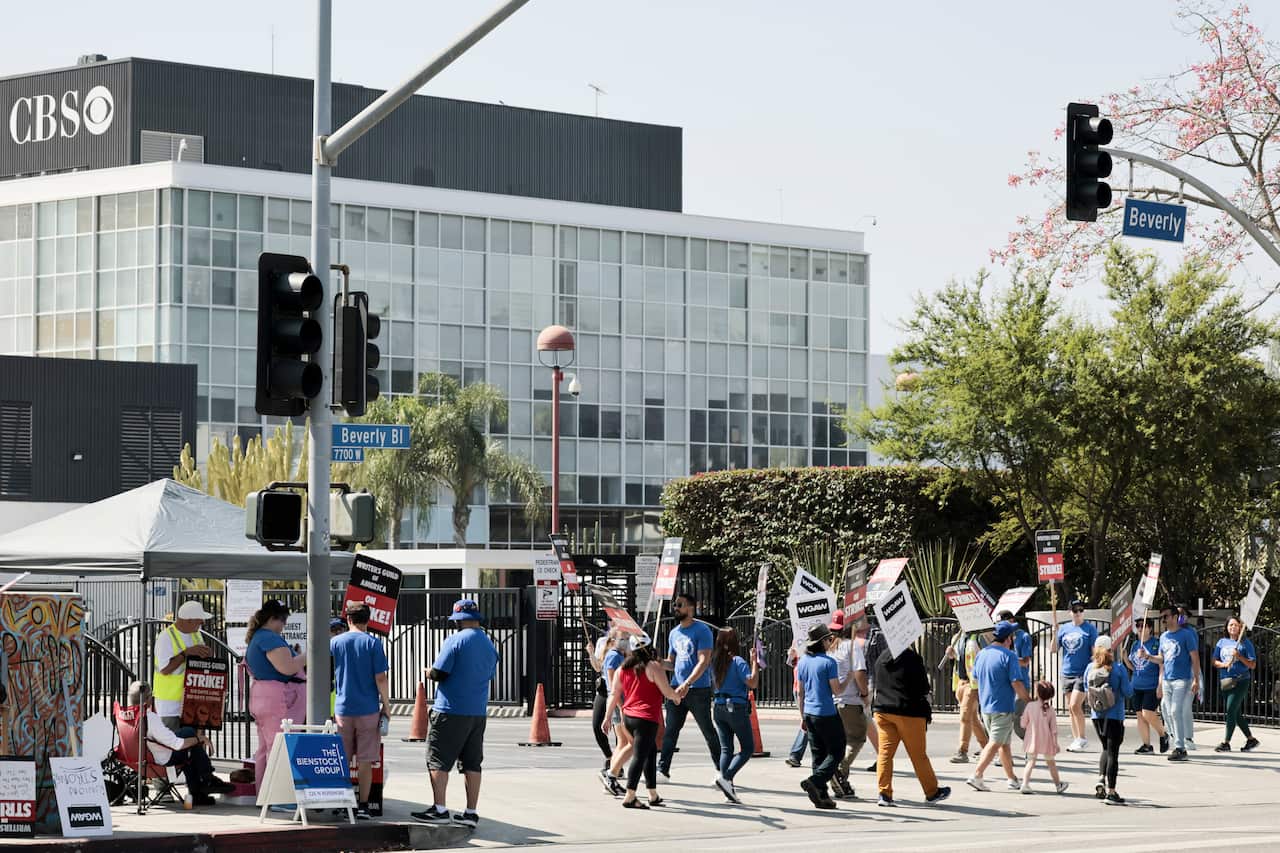 People holding placards protesting outside a building.