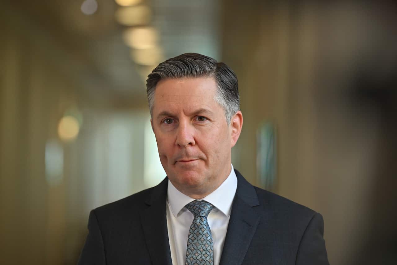 A man in a black suit and white shirt