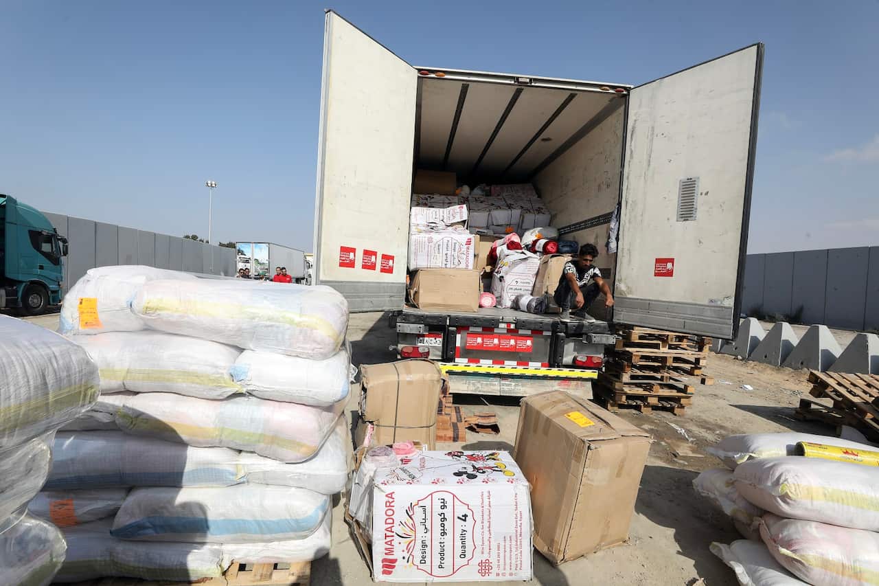 Egyptian volunteers handle humanitarian aid bound for Palestinians in the Gaza Strip, at the Rafah border crossing 