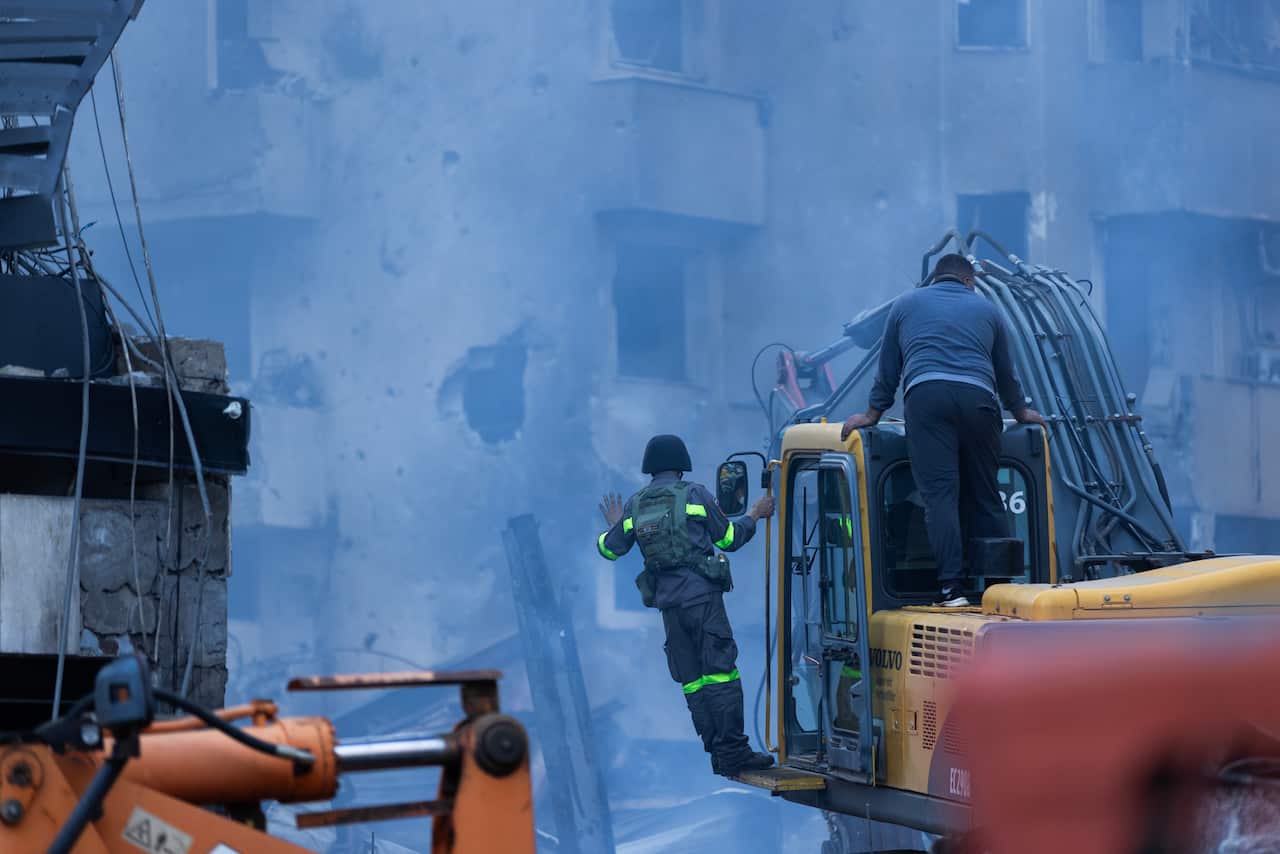 Rescue workers near a heavily damaged building.