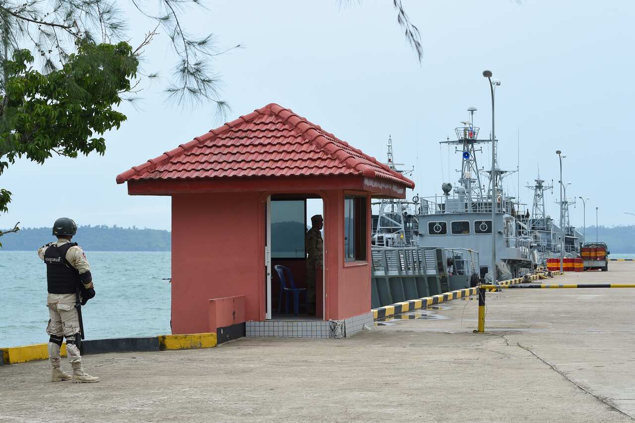 A military office standing on a jetty at a naval base.