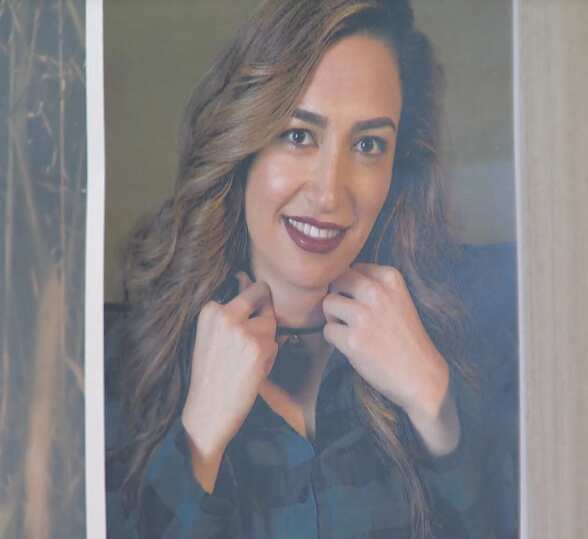 A screenshot showing a professional portrait shot of a woman.