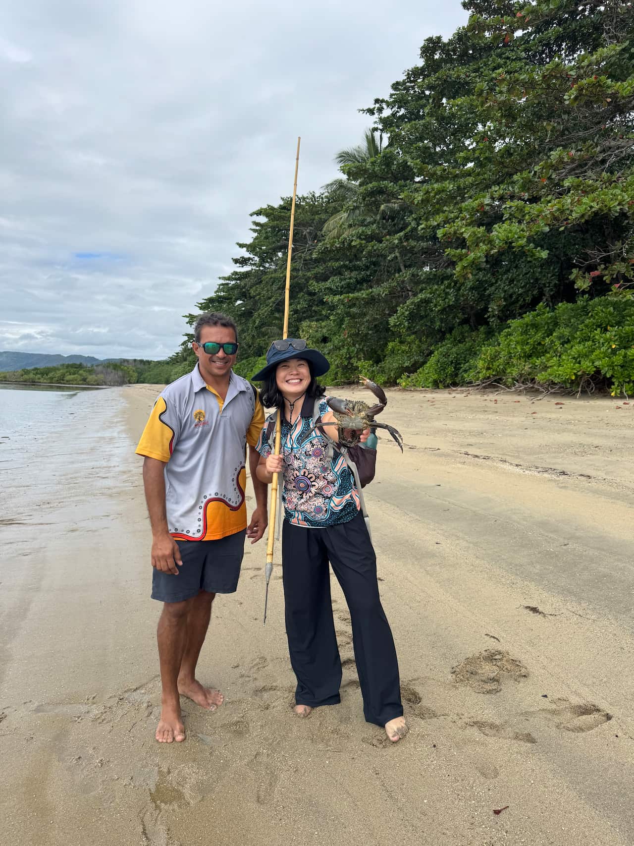 A Chinese woman holds a mud crab, next to a First Nations man.