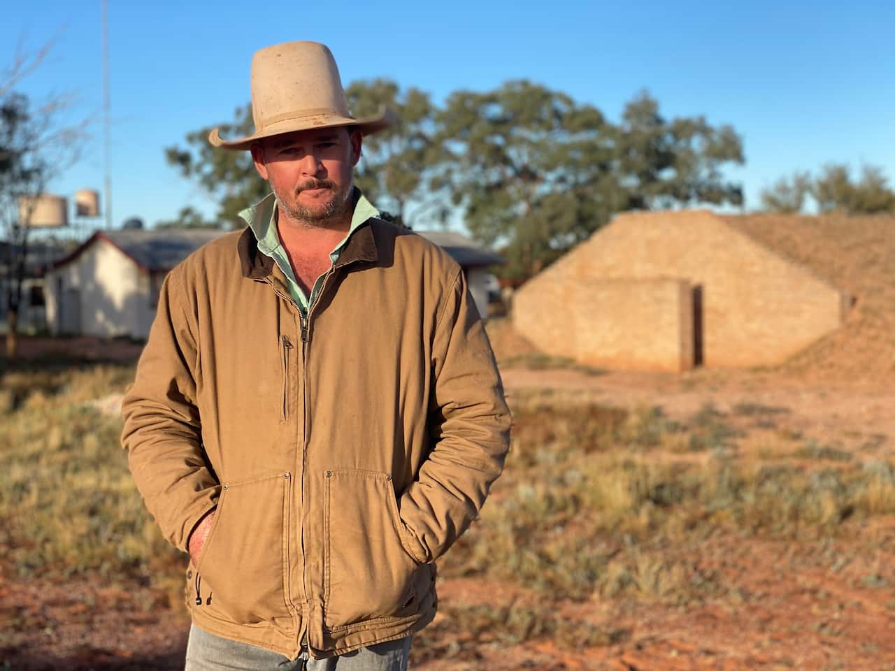 Farmer standing outside cattle station property.